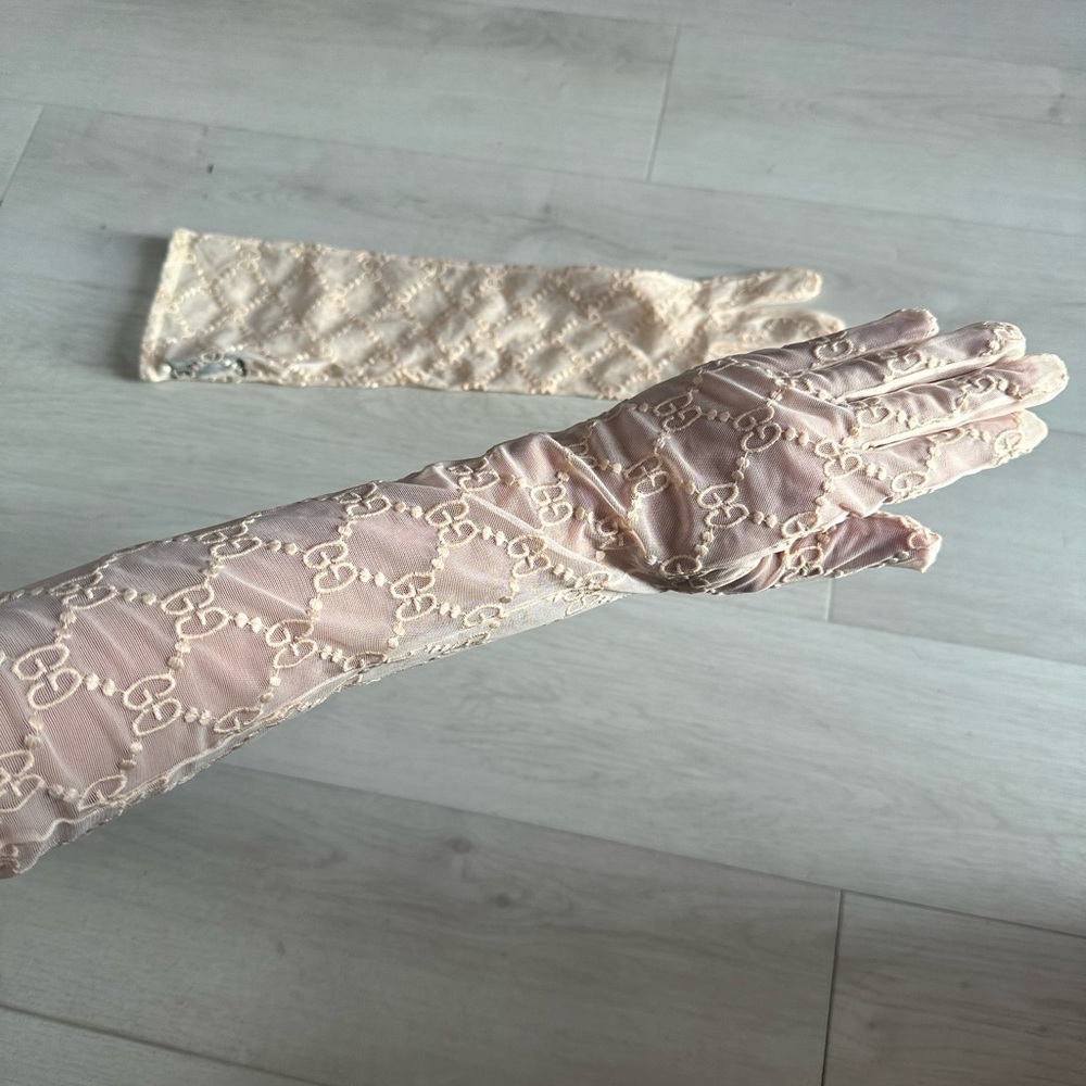 Tulle Gucci cream gloves with GG monogram secured around arm with light elastic